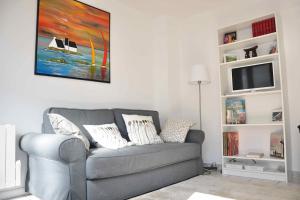 sala de estar con sofá gris y TV en Confortable appartement à 300m de la plage, en Saint-Nazaire