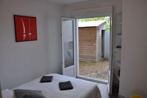Un dormitorio con una cama y una puerta corrediza de vidrio. en Confortable appartement à 300m de la plage, en Saint-Nazaire