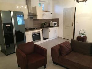 a living room with a couch and a kitchen at Maison de campagne in Le Baizil