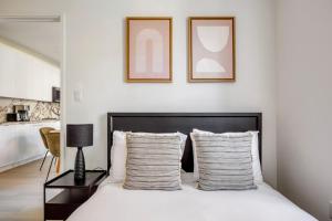 a bedroom with a bed with two framed pictures on the wall at Blueground Chelsea elev wd nr 8th Ave NYC-1451 in New York