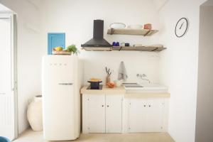 uma cozinha com um frigorífico branco e um lavatório em Skafè Apartments em Uggiano la Chiesa