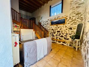 a room with a stone wall and a staircase with towels at Au pied du château avec terrasse - CLG Savoie - 1Ch - 1SDB in Fréterive
