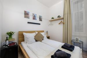 - une chambre avec un lit doté de draps et d'oreillers blancs dans l'établissement AK7 Boutique Suites, à Budapest