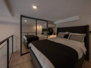 ein Schlafzimmer mit einem großen Bett und einem Spiegel in der Unterkunft Sale! BTS On Nut tallest/36th floor/gym/fast Wi-fi in Amphoe Phra Khanong
