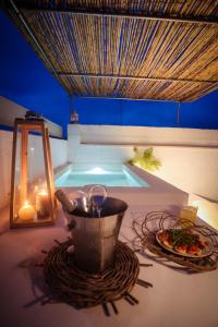 Una mesa con una olla y un plato de comida junto a una piscina. en Skafè Apartments, en Uggiano la Chiesa