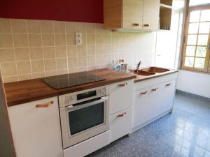 a kitchen with white cabinets and a stove top oven at Maison au calme avec jardin à 5 min de Tournus in Cuisery
