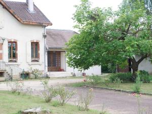 a white house with a tree in front of it at Maison au calme avec jardin à 5 min de Tournus in Cuisery