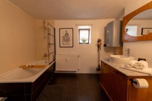 ein Badezimmer mit einer Badewanne, einem Waschbecken und einer Badewanne in der Unterkunft Ferienwohnung Landscapeapartment, 46qm Individual Fewo mit Fernblick ins Zittauer Gebirge, Ferienapartment im historischen Altstadtkern Zittau in Zittau