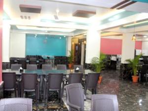 a conference room with chairs and a table and a screen at Hotel Tarasrushti in Pune