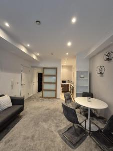 a living room with a couch and a table and chairs at Modern Apartment in City Centre in Manchester