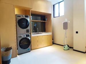 eine Waschküche mit einer Waschmaschine und einem Waschbecken in der Unterkunft City Comfort Inn Jiujiang Gongqing Science and Technology College High-speed Railway Station in Gongqingcheng