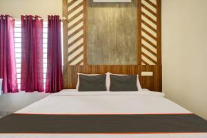 a bedroom with a large bed with purple curtains at GYPSY HOTEL CUSAT in Cochin