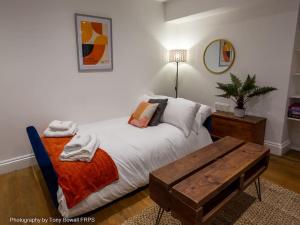 een slaapkamer met een bed en een houten tafel bij Central seaside home with peaceful patio in Brighton & Hove