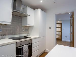 een keuken met witte kasten en een fornuis met oven bij Central seaside home with peaceful patio in Brighton & Hove