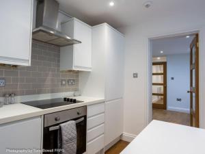 a kitchen with white cabinets and a stove top oven at Central seaside home with free parking in Brighton & Hove