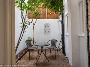 eine Terrasse mit einem Tisch und Stühlen auf einer Terrasse in der Unterkunft Central seaside home with peaceful patio in Brighton & Hove