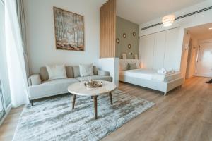 uma sala de estar com um sofá e uma mesa em Cozy Studio with Balcony in The Greens em Dubai