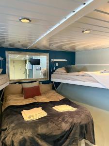 a bedroom with two bunk beds and a large mirror at Hotellilaiva Wuoksi in Kuopio