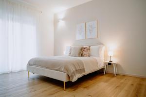 1 dormitorio con 1 cama grande, paredes blancas y suelo de madera. en Alatea Apartments Valverde en Verona