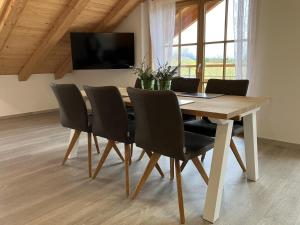 mesa de comedor con sillas y TV en Bergbauernhof Wechs en Ofterschwang