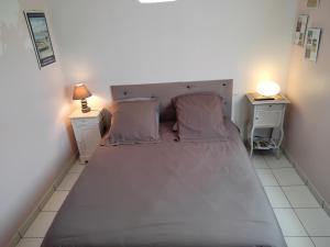 1 dormitorio con 1 cama grande y 2 mesitas de noche en La P'tite Etape, en Talmont