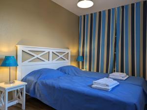 a bedroom with a blue bed with towels on it at Résidence Mes Amours d'Enfants - Les Villas du Lac in Soustons +114 photos