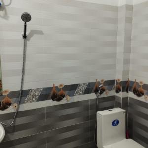 a bathroom with a toilet and a shower at Quỳnh Hà in Diện Biên Phủ
