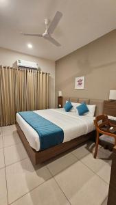 a bedroom with a large bed with blue pillows at Kaloor Residency in Ernakulam