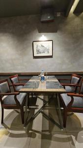 a dining room with a wooden table and chairs at Kaloor Residency in Ernakulam