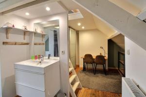 een badkamer met een wastafel en een eetkamer bij Chambre d hôtes - studio de 30m2 in Rixensart