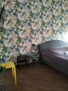 a bedroom with a bed and a floral wallpaper at Appartamento Cenisia Fermata Racconigi in Turin