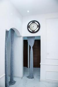 a clock sitting on top of a wall with curtains at House 13 Apex in Lagos