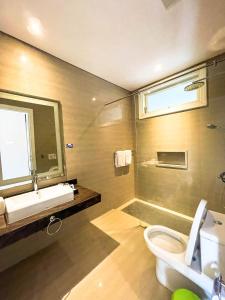 外南夢的住宿－新蘇里亞酒店，浴室配有卫生间、盥洗盆和淋浴。