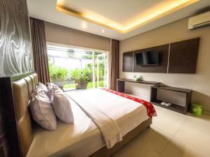 a bedroom with a large bed with a large window at New Surya Hotel in Banyuwangi