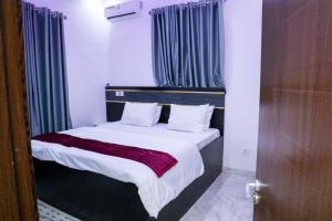 a bedroom with a large bed with blue curtains at House 13 Apex in Lagos