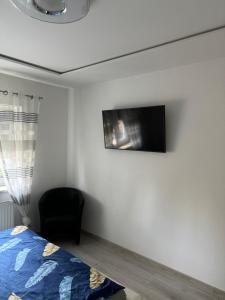 a bedroom with a bed and a tv on the wall at Willa Euforia in Poznań