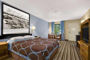 a hotel room with a bed and a flat screen tv at Super 8 by Wyndham Oxford in Oxford
