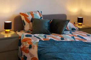 ein Schlafzimmer mit einem Bett mit zwei Lampen an Tischen in der Unterkunft Cosy Zenith Purpan in Toulouse