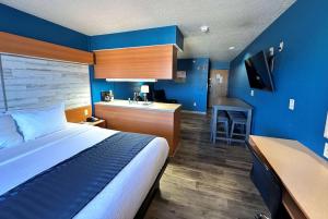 Un dormitorio con una cama y una cocina con fregadero. en Microtel Inn & Suites Tomah, en Tomah