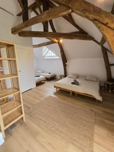 a bedroom with a bed in a attic with wooden beams at Magnifique propriété en pierre in Sceaux-du-Gâtinais