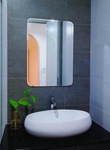 a bathroom with a white sink and a mirror at Lullaby homestay in Hue
