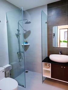 a bathroom with a sink and a glass shower at Lullaby homestay in Hue
