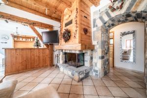 a living room with a stone fireplace and a tv at Le Torrent des Lys in Samoëns