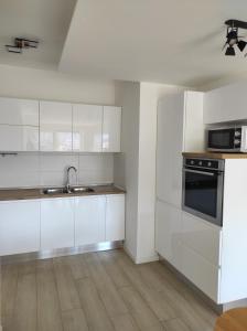 a kitchen with white cabinets and a sink and a stove at Appartamento al Sereno in Luino