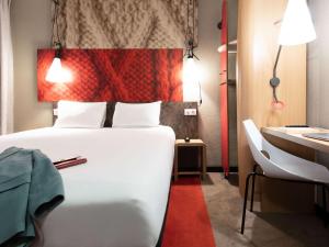 a bedroom with a large white bed and a desk at ibis Paris Grands Boulevards Opéra 9e in Paris