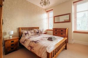 una camera con letto, cassettiera e finestre di Fonthill Residence - SJA Stays - 1 Bed Apartment ad Aberdeen