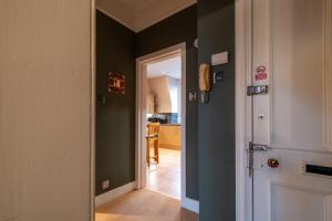 a hallway with green walls and a white door at Fonthill Residence - SJA Stays - 1 Bed Apartment in Aberdeen