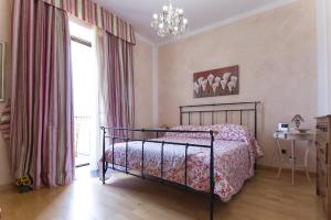 a bedroom with a bed and a chandelier at Piazza Civica in Alghero