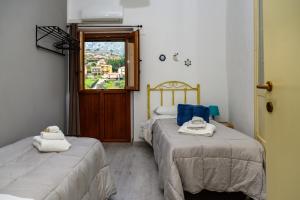 two beds in a room with a window at Mirose's holiday home 39 in Castelbuono