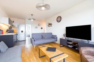 ディジョンにあるLE PANORAMA à deux pas du centre villeのソファと薄型テレビのあるリビングルーム